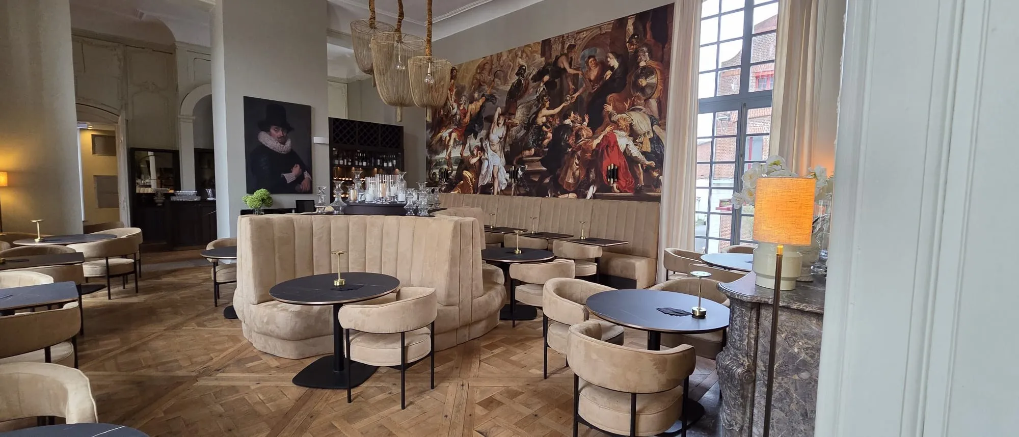 Rund polstret benk og lenestoler i beige i restaurantdelen på et firestjerners hotell