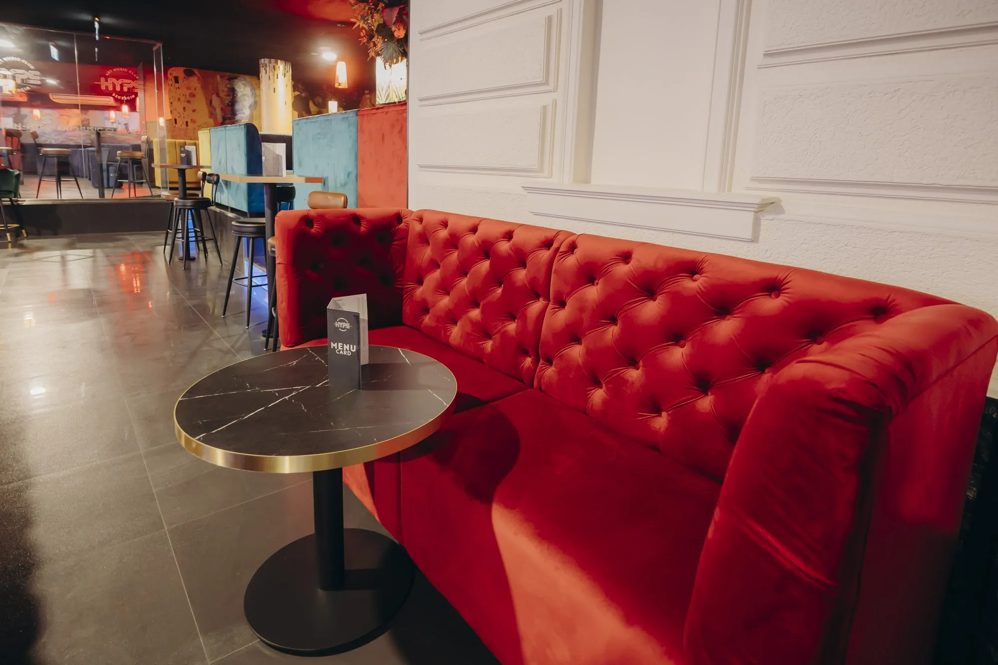 Rød CHESTERFIELD-sofa i velur med capitonné-søm i VIP-sonen på en nattklubb