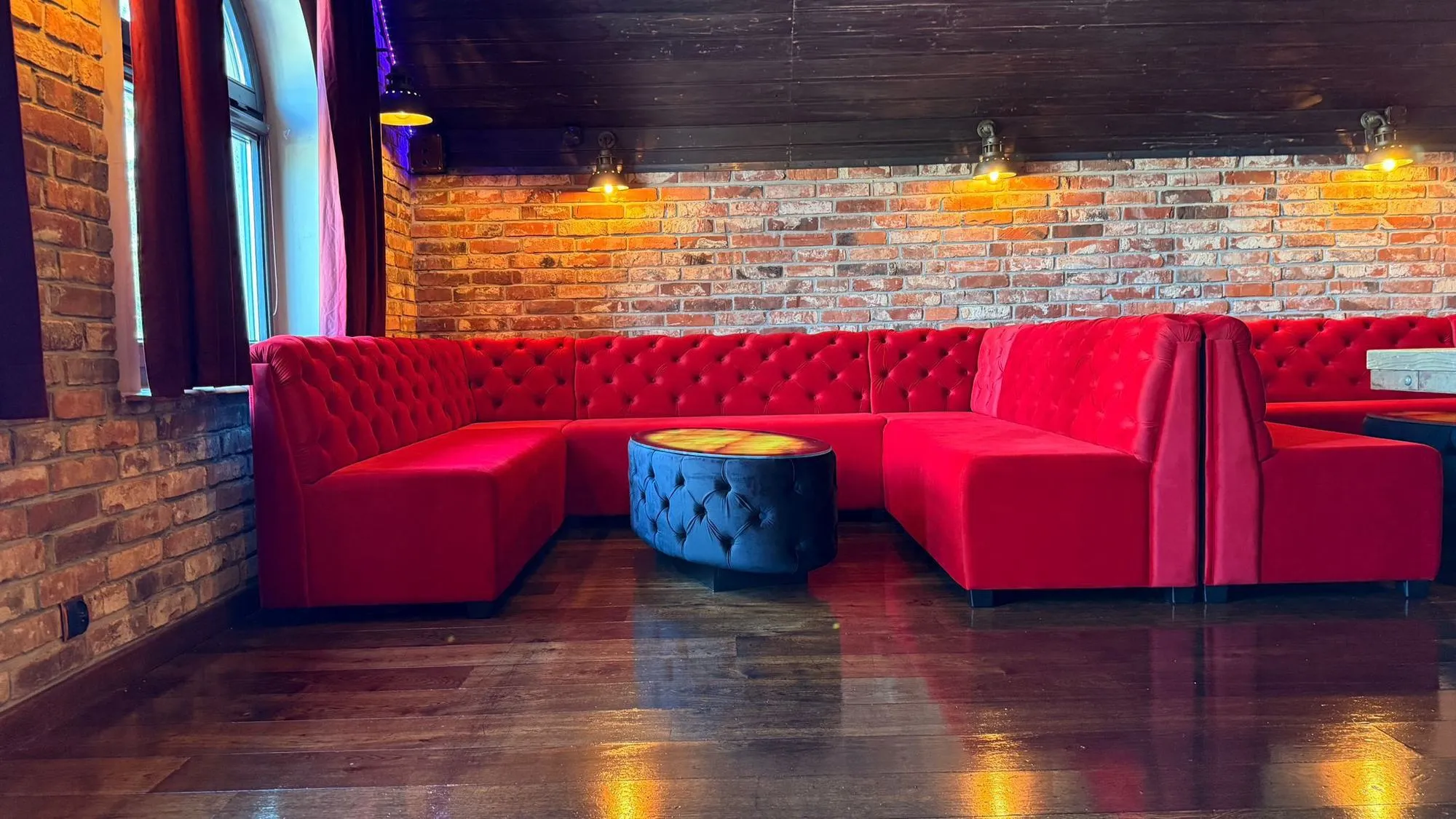 Hjørnesofa i bar med mørk polstring, Stara Przepompownia 2.0