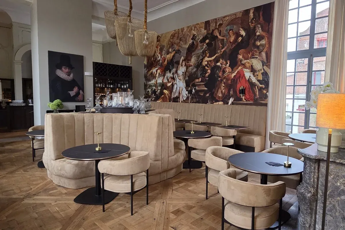 Rund polstret sofa og stoler i restaurantsalen på Hôtel Royal Beaulaincourt i Frankrike